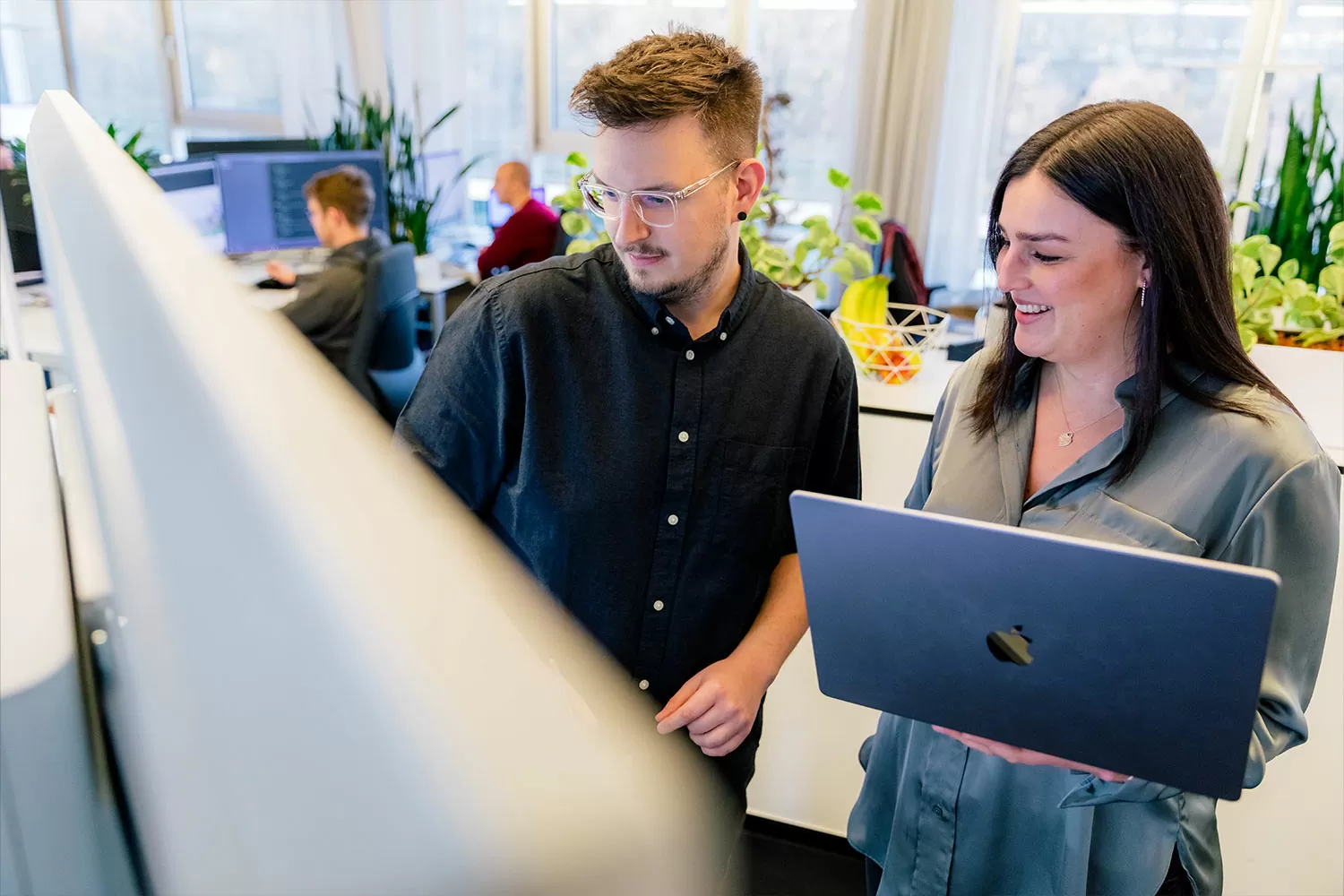 Zwei Mitarbeiter betrachten ein Whiteboard