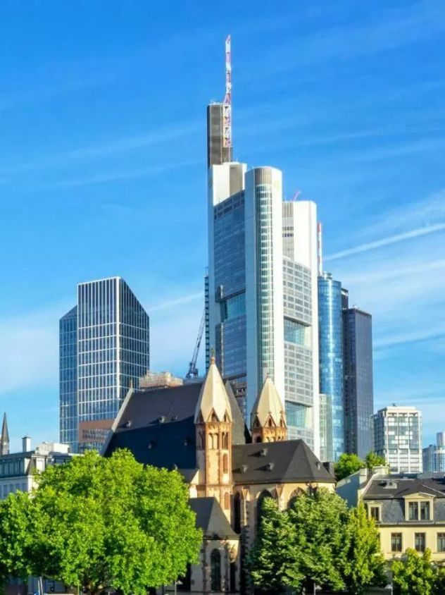 Frankfurter Skyline mit modernen Hochhäusern und historischer Kirche im Vordergrund
