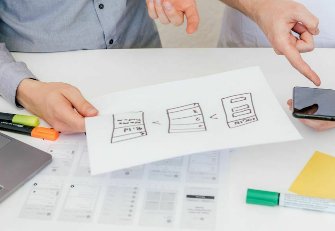 Zwei Personen arbeiten an einer Idee an einem Tisch.