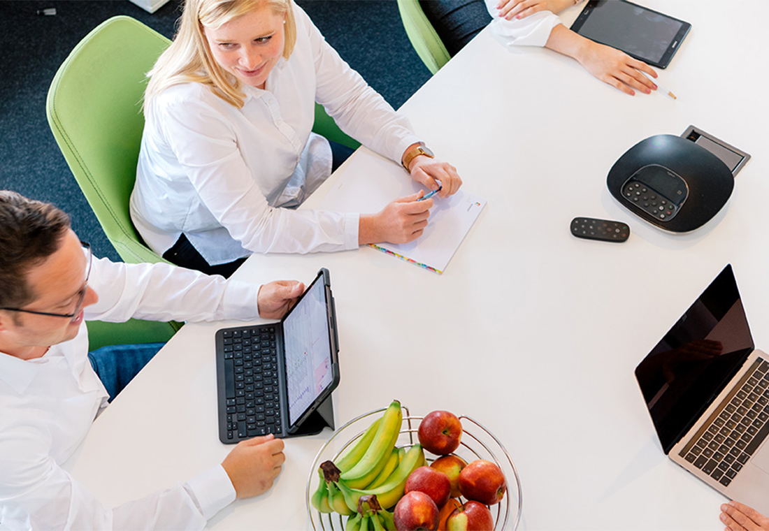 Online-Marketing-Coaching: Wissenstransfer von Online-Marketing-Experten Eine Gruppe von Menschen sitzt um einen Tisch mit Laptops und diskutiert angeregt.