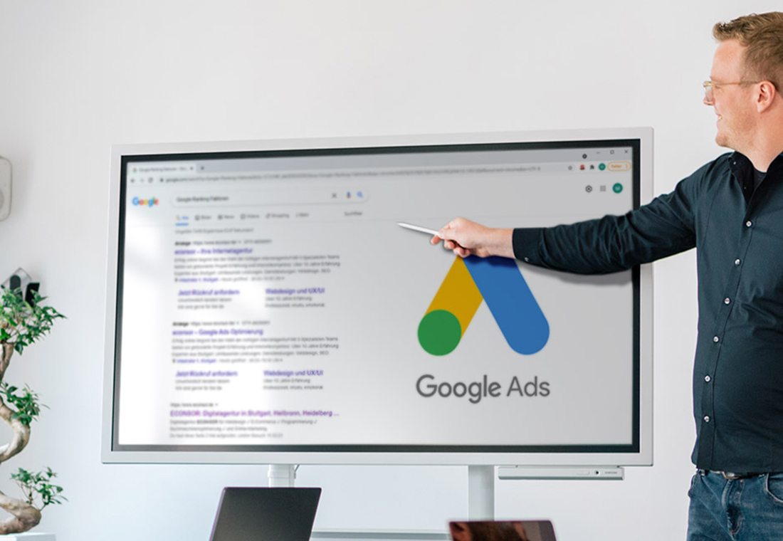 google-ads Ein Mann zeigt auf Google-Anzeigen, die auf einem weißen Brett skizziert sind.
