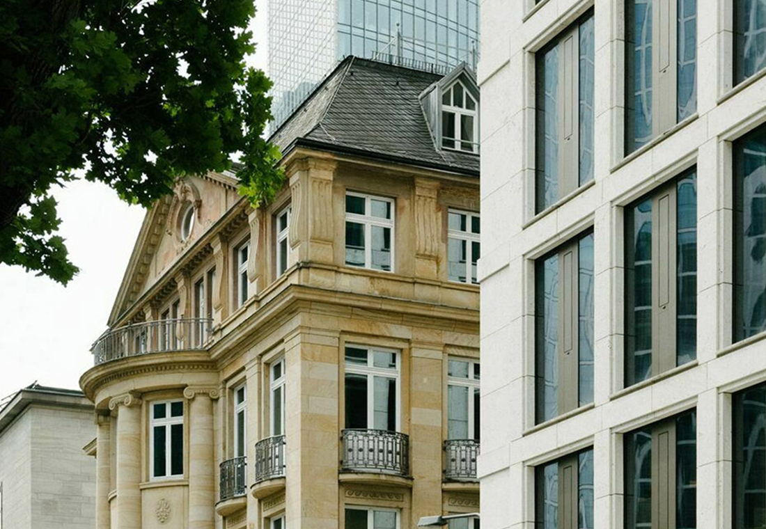 Ein Gebäude mit einem Uhrturm im Vordergrund, das eine markante architektonische Struktur darstellt.