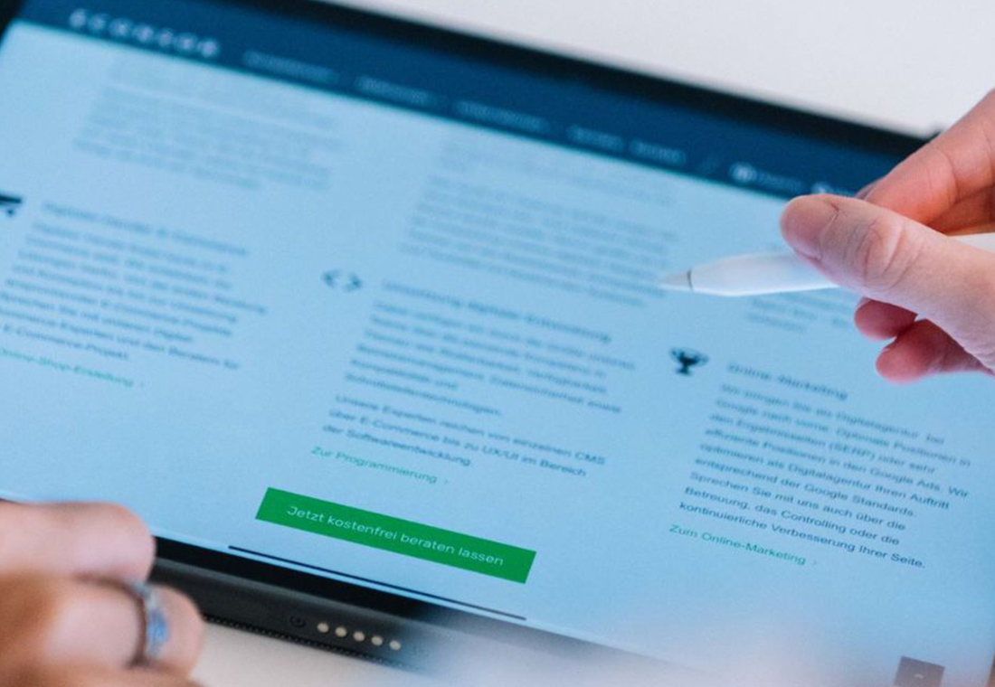 SEO Performance-Optimierung zur Ranking-Verbesserung Eine Person mit Tablet und Stift, die das Ranking überprüft nach der SEO Performance-Optimierung