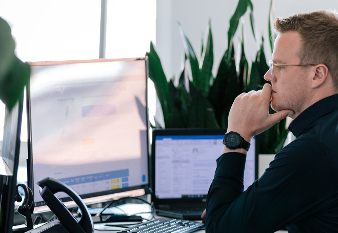 Headless CMS oder TYPO3 Mitarbeiter sitzt konzentriert am PC und arbeitet.