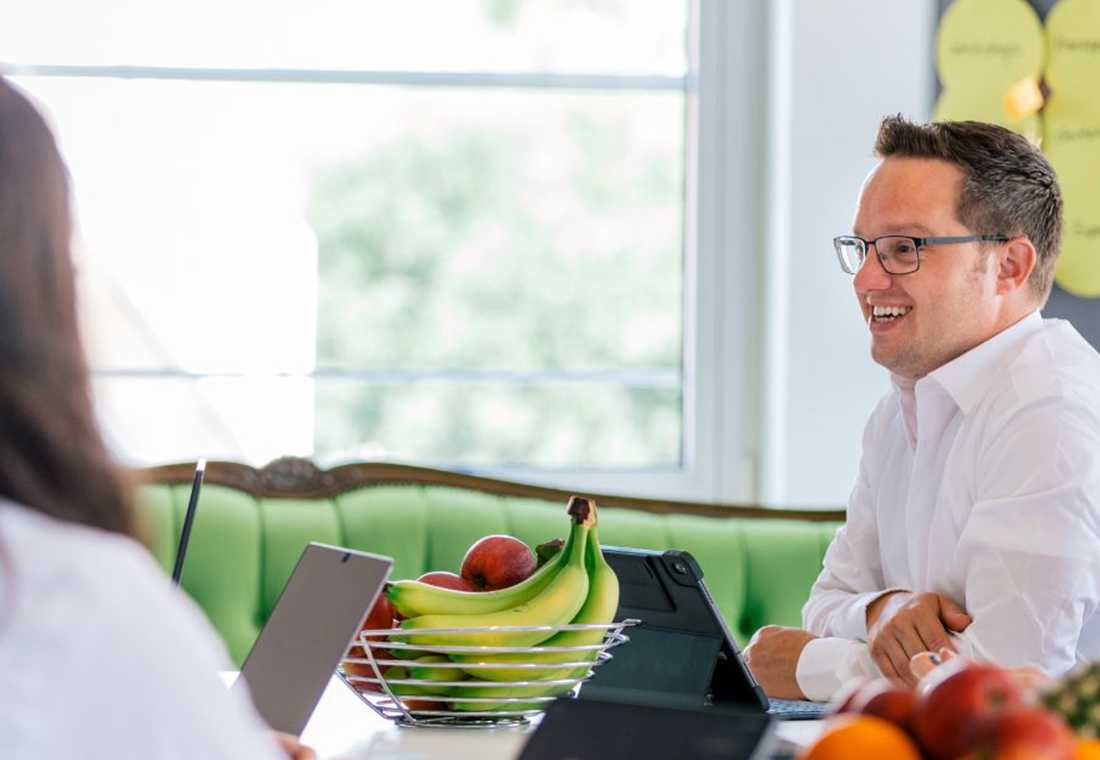 Personen sitzen in einem Konferenzraum und besprechen ein weiteres Vorgehen.
