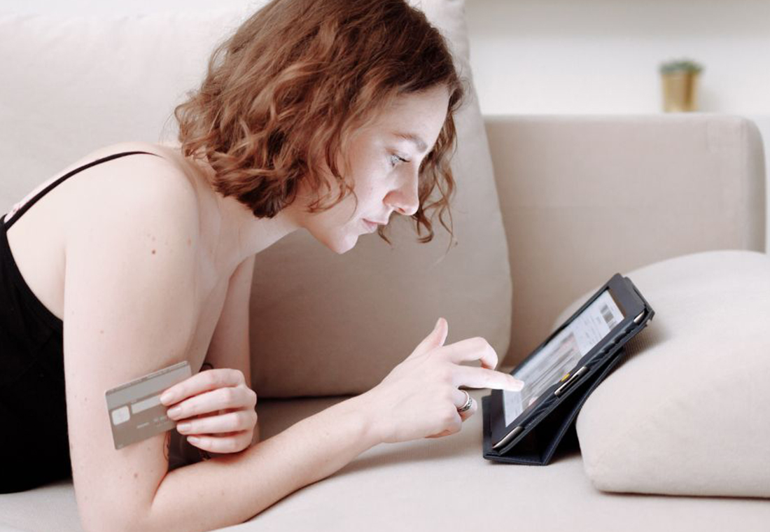 personalisiertes-marketing Frau auf Sofa kauft in einem Onlineshop ein.