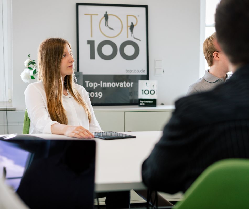 Eine Mitarbeiterin im Besprechungszimmer mit zielgerichtetem Blick nach vorn Eine Mitarbeiterin im Besprechungszimmer mit zielgerichtetem Blick nach vorn