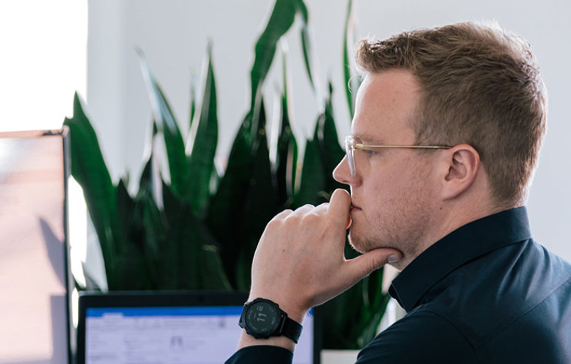 Ein Entwickler von der Seite, der an einem Computer arbeitet