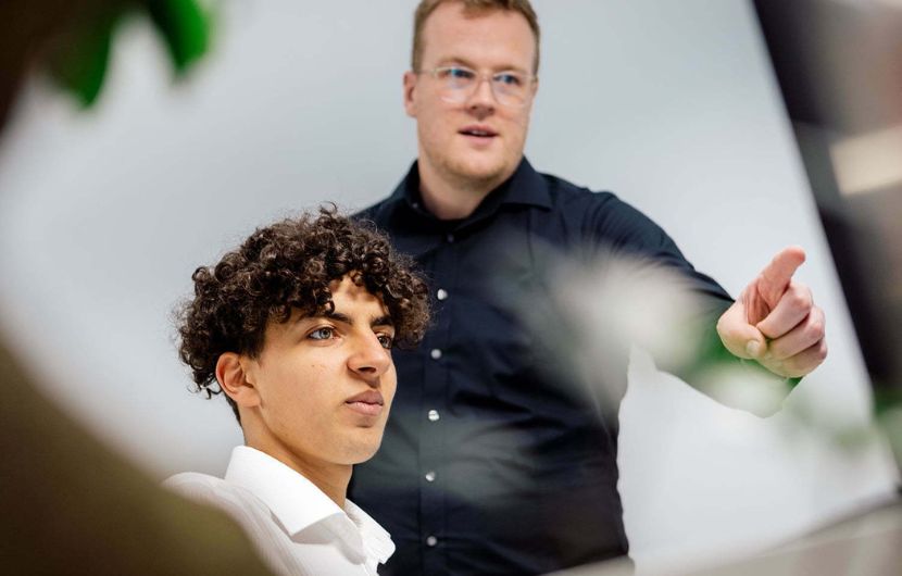 TYPO3-Mitarbeiter Zwei Mitarbeiter arbeiten gemeinsam an einem Computer in der TYPO3-Agentur