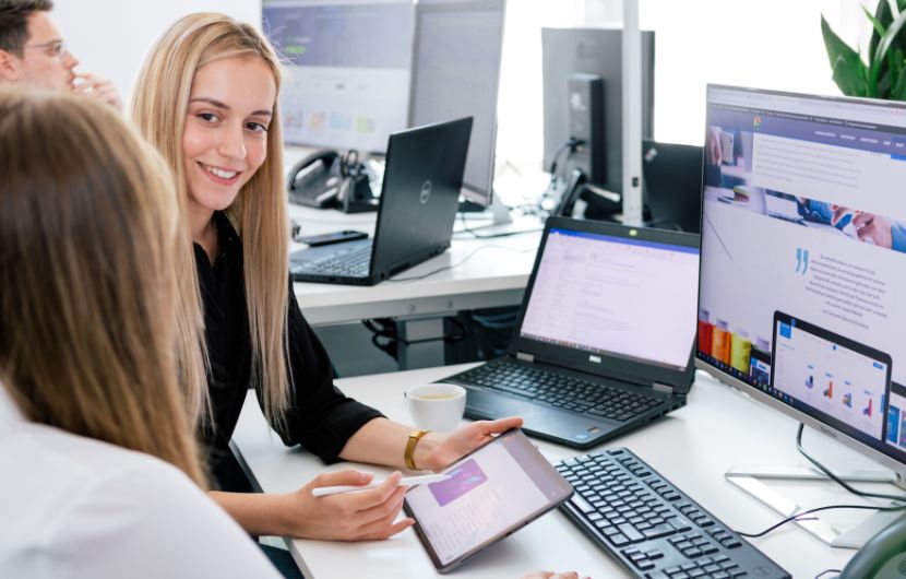 Agentur für SEO In einem großzügigen Büro planen Mitarbeiter einer Performance-Marketing-Agentur digitale Kampagnen und analysieren detaillierte Kennzahlen – die Szene vermittelt eine professionelle und innovative Agentur für Performance-Marketing.