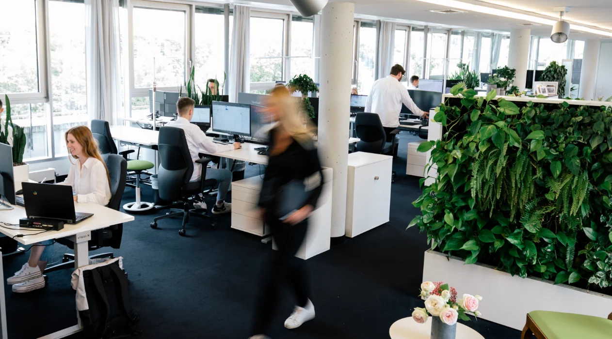 Mehrere Mitarbeiter arbeiten in einem belebten Büro