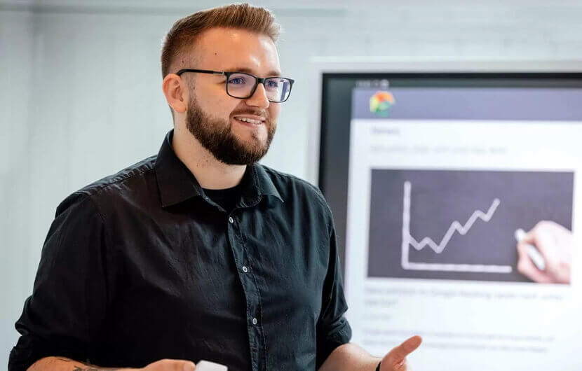 Conversion-Optimierung – Mehr Umsatz Kollege steht am Smartboard und schult einen Kunden