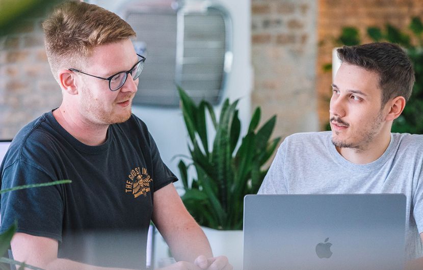 Zwei Mitarbeiter unterhalten sich über aktuelle E-Commerce Trends