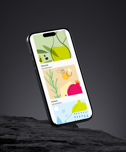 edesma-bilderreihe-1 Ein Smartphone steht hochkant auf einem düsteren und unebenem Stein. Auf dem Bildschirm des Smartphones ist der EDESMA-Shop abgebildet.