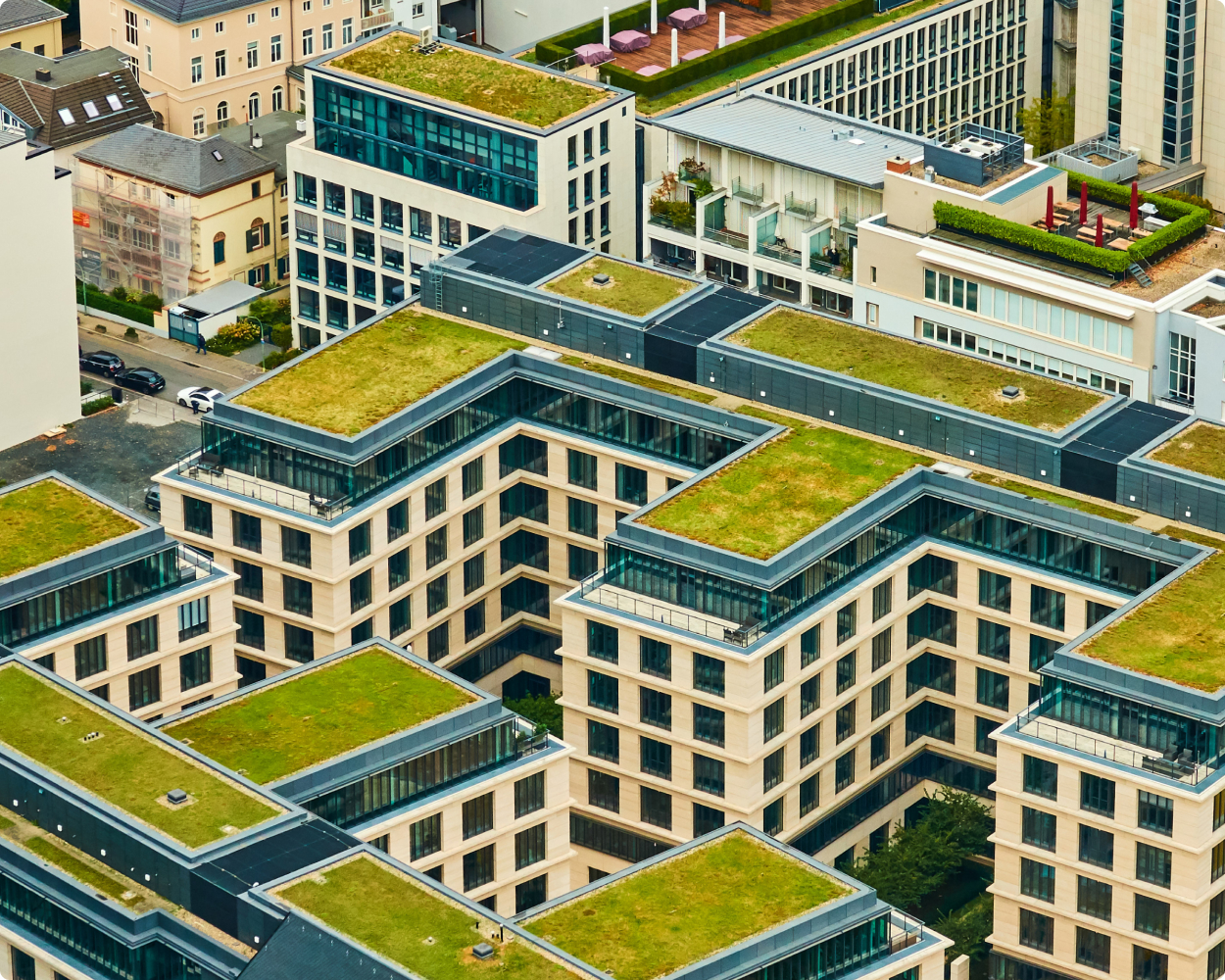 Moderne Hochhäuser mit integrierten Grünflächen und urbanem Umfeld – nachhaltige Stadtentwicklung mit Lösungen von FIRTZTechnologien.