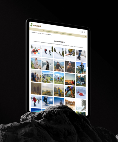 Ein Tablet steht hochkant auf einem düsteren und unebenem Stein. Auf dem Bildschirm des Tablets ist der naturzeit-Shop abgebildet.