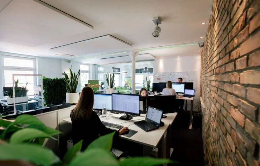 Ein Büroweitblick mit Mitarbeitern, die an Ihren Schreibtischen arbeiten