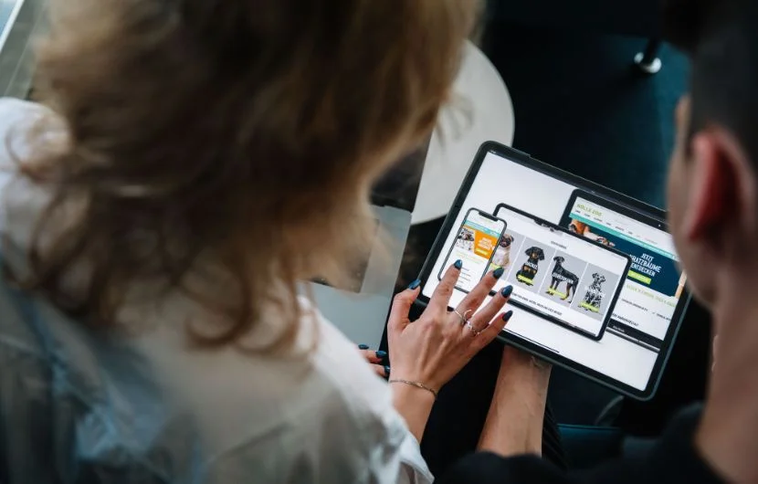 Ihre Online-Marketing-Agentur in Stuttgart Zwei Kollegen, die sich auf einem Table ein Kundenprojekt ansehen.