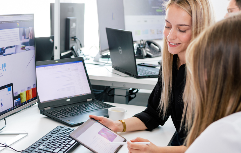 Zwei Content-Marketing-Profis besprechen sich vor einem Computer