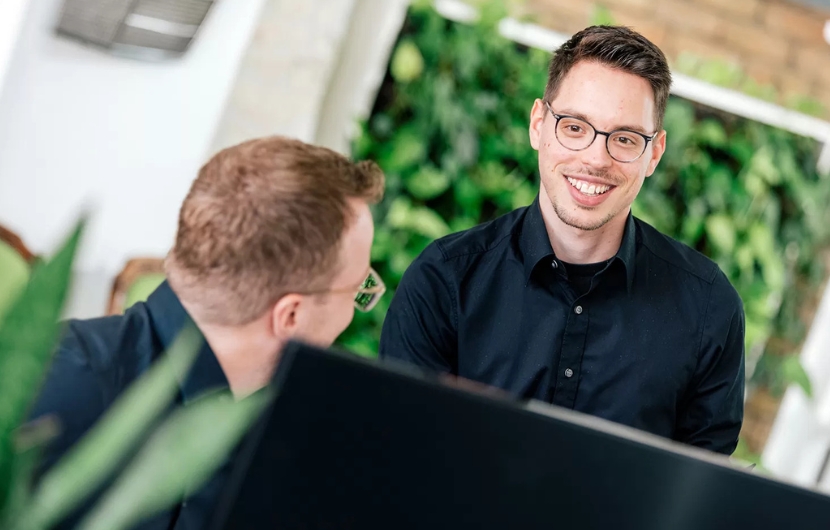 Online-Marketing-Profis Zwei Online-Marketing-Profis besprechen sich vor einem Computer