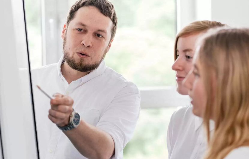 Ein Experte berät einen Kunden in einem modernen Büro über individuelle E-Commerce-Lösungen für B2C und B2B – unterstrichen durch den Einsatz von Online-Marketingstrategien für den Erfolg im Online-Shop.