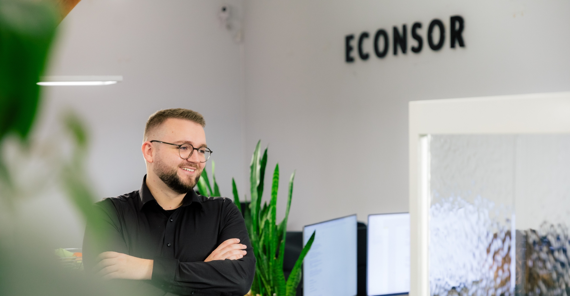 Seitliches Profil des Teamleiters, hinter ihm das Econsor-Logo.