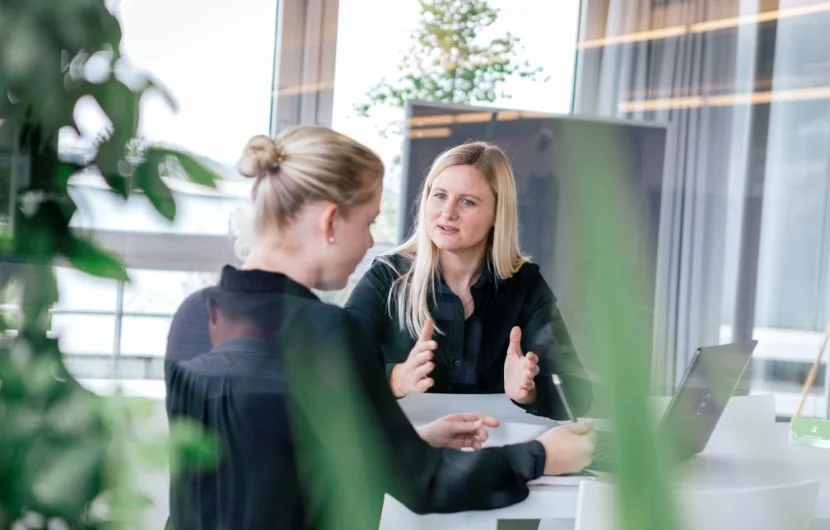 Ihre SEO Agentur in Karlsruhe Zwei Mitarbeiterinnen befinden sich in einem Besprechungsraum mitten im Gespräch