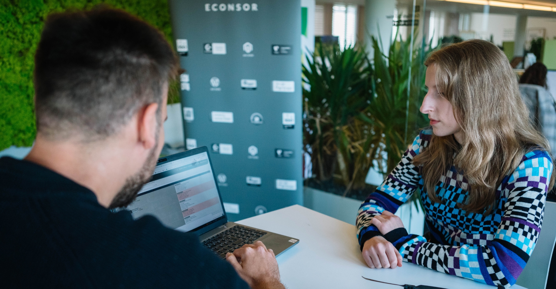 Am Laptop prüfen zwei Mitarbeitende einen Tracking-Report.