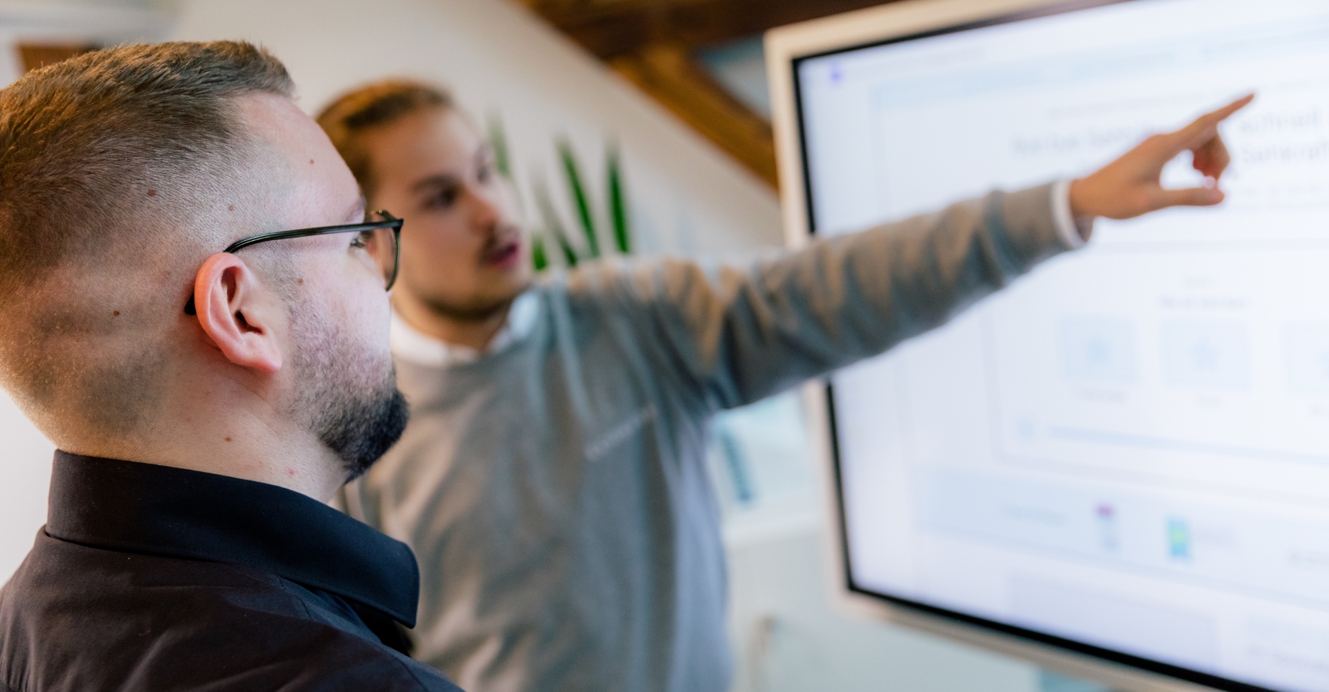 typo3-mannheim Ein Mitarbeiter zeigt seinem Kollegen etwas auf dem Bildschirm