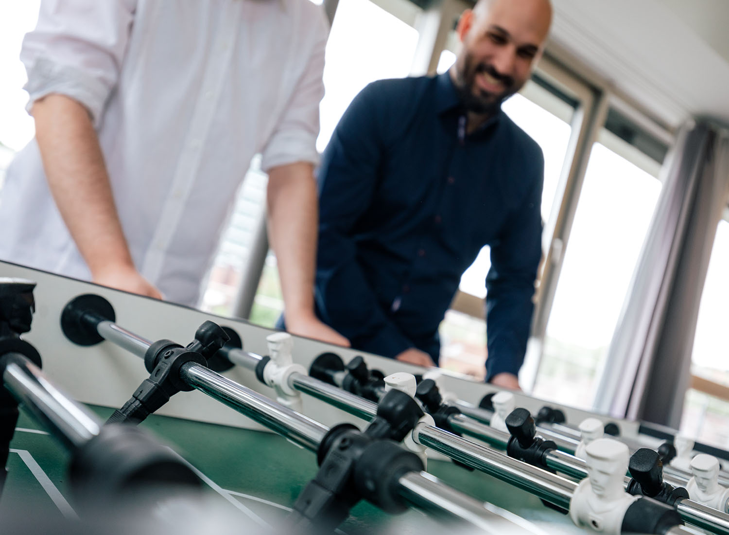 Mitarbeiter bei ECONSOR Zwei Mitarbeiter spielen Tischkicker