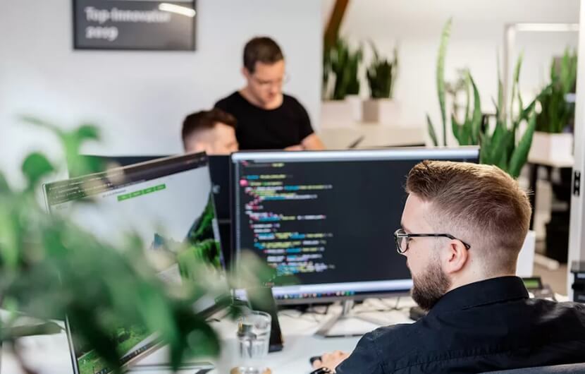 webdesign-agentur-heidelberg Mitarbeiter im Büro während der Fokus auf einem liegt, welcher programmiert