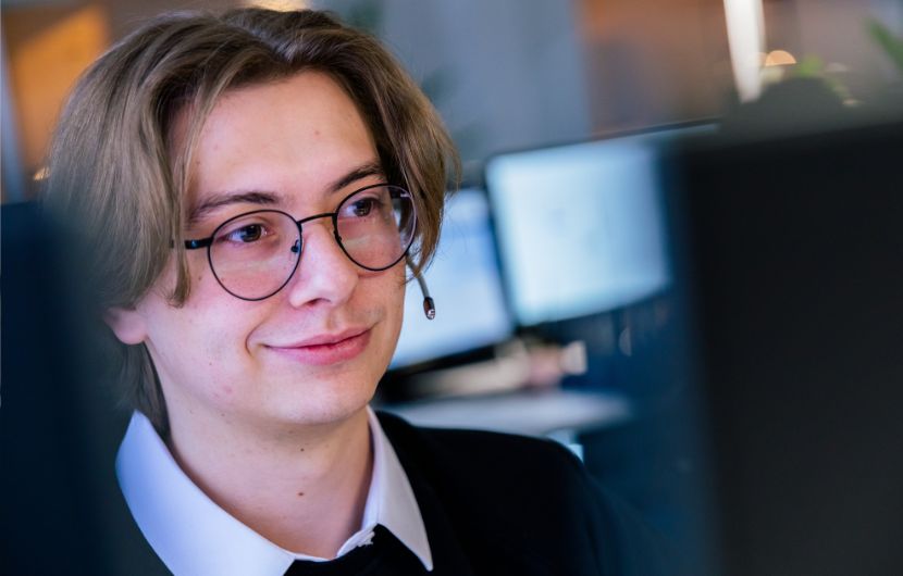 Ein Webentwickler arbeitet an einem Computer, programmiert und ist tief konzentriert auf seine Aufgabe.