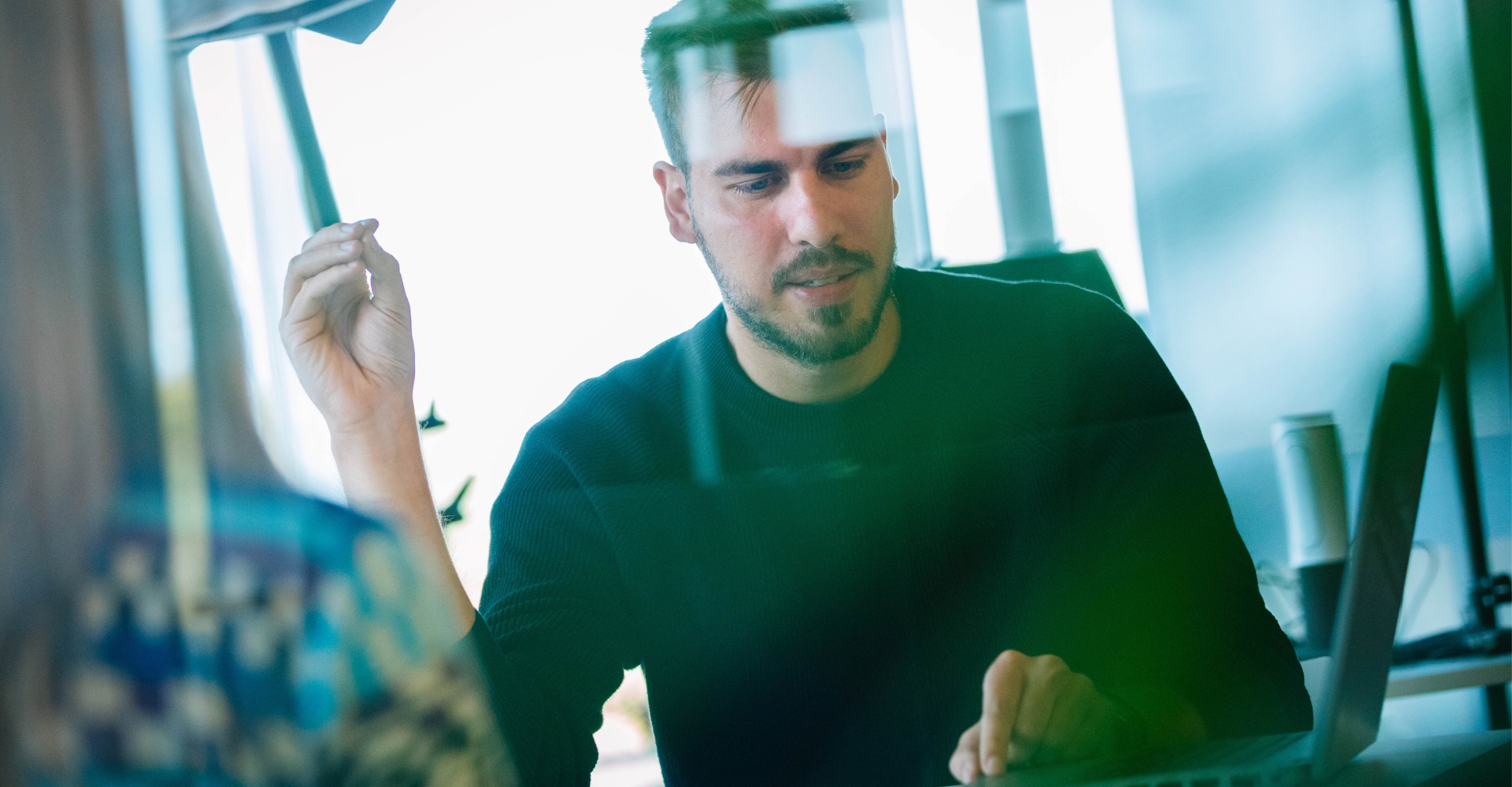 Ein Mitarbeiter zeigt einem Kollegen etwas auf dem Laptop.