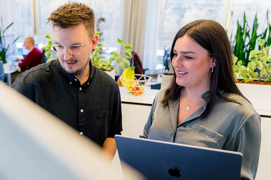 Ihre Shopware-Agentur Zwei Econsor-Mitarbeiter stehen vor einem Smartboard und besprechen über ein Shopware-Projekt.