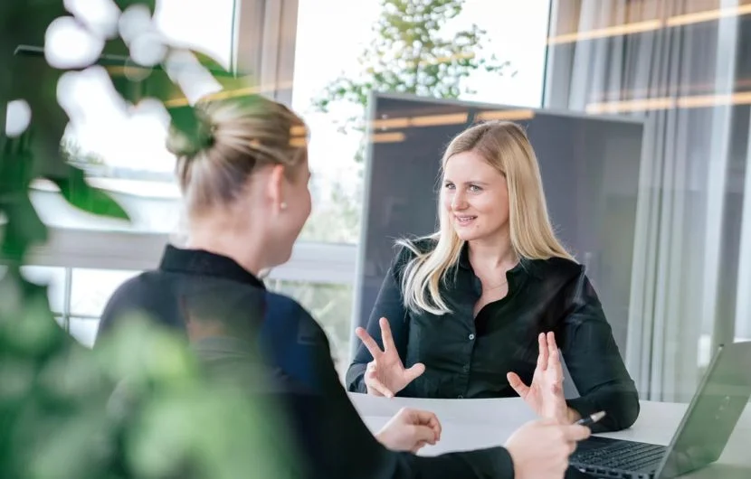 Agentur für digitale Beratung im Gespräch Zwei Mitarbeiterinnen besprechen strategische Webthemen in einem hellen Besprechungsraum – Fokus auf individuelle digitale Beratung.